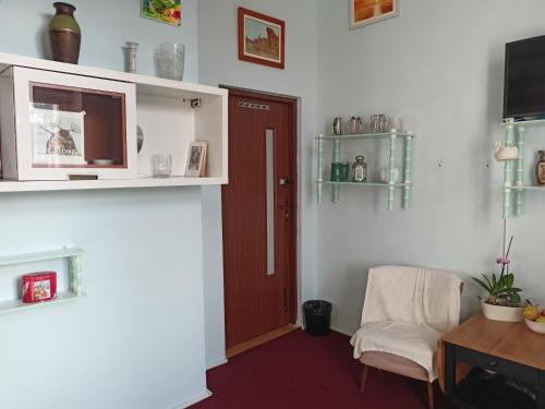 een kamer met een stoel, een tafel en een deur bij - PASTELOWY loft - in Sopot