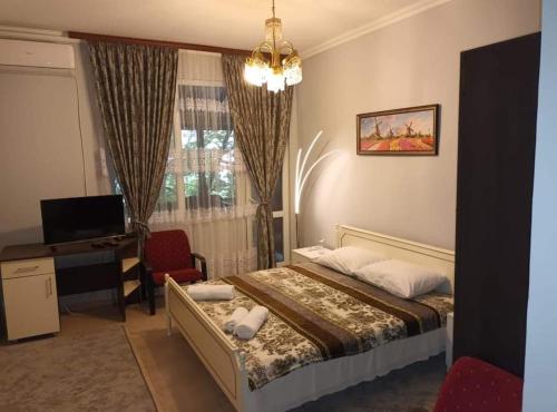 a bedroom with a bed and a desk and a computer at CITY HOUSE in Dulovo