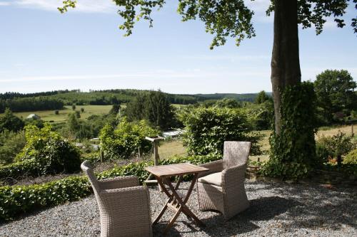 ein Tisch und Stühle mit Blick auf ein Feld in der Unterkunft La Lune d'Or in Redu