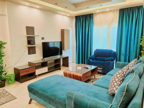 a living room with a blue couch and a television at Discover Inn in Alexandria