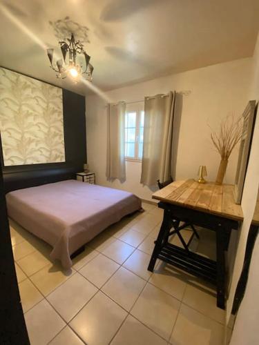 a bedroom with a bed and a table in it at lé z'orangines in Saint-Benoît