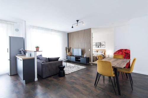 a living room with a table and a couch and a bedroom at Appartement grande terrasse proche de Tours centre in Tours