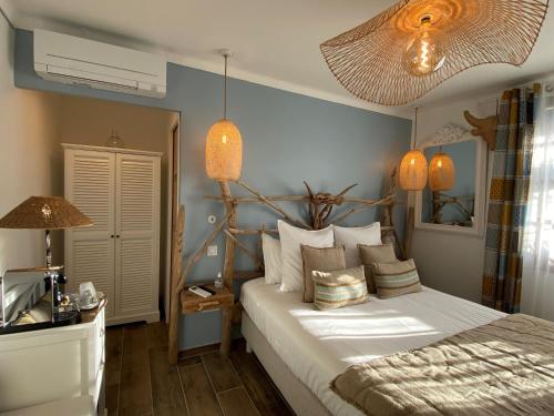 a bedroom with a large bed with pillows at Hôtel Le Neptune en Camargue in Saintes-Maries-de-la-Mer