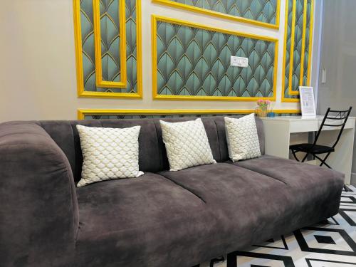 a brown couch in a room with a table at The First Floor I Top Rated Boutique Homestay I Near Lekhraj Metro Lucknow in Lucknow