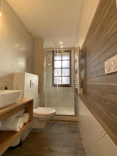 La salle de bains est pourvue de toilettes, d'un lavabo et d'une douche. dans l'établissement Hôtel Le Neptune en Camargue, à Saintes-Maries-de-la-Mer