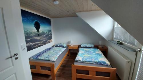 two beds in a room with a painting on the wall at Haus Rheinglück "Liebenstein" in Kamp-Bornhofen