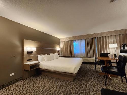 ペンティクトンにあるDays Inn by Wyndham Penticton Conference Centreのベッドとデスクが備わるホテルルームです。