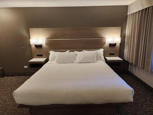 a large bed in a hotel room with two lamps at Days Inn by Wyndham Penticton Conference Centre in Penticton