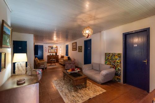 ein Wohnzimmer mit einem Sofa und einem Tisch in der Unterkunft Reduto das Artes Hostel pousada in Casa Branca
