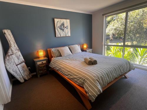 a bedroom with a bed with a teddy bear on it at Bay Breeze Retreat in Cowes