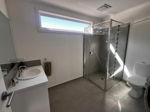 a bathroom with a shower and a toilet and a sink at Bay Breeze Retreat in Cowes