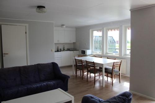 a living room with a couch and a table with chairs at Sandby Pensionat in Löttorp