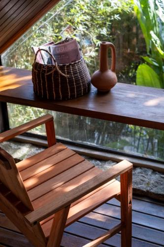 a wooden chair and a vase sitting on a table at Casa Luz Paraty in Paraty