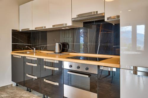 a kitchen with white cabinets and a wooden counter top at Apartments Frlan in Kastav