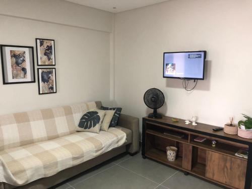 a living room with a couch and a flat screen tv at Apto 70m² no centro de Porto Belo in Porto Belo