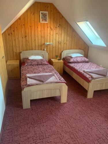 two beds in a room with a attic at Napfény apartman in Orosháza