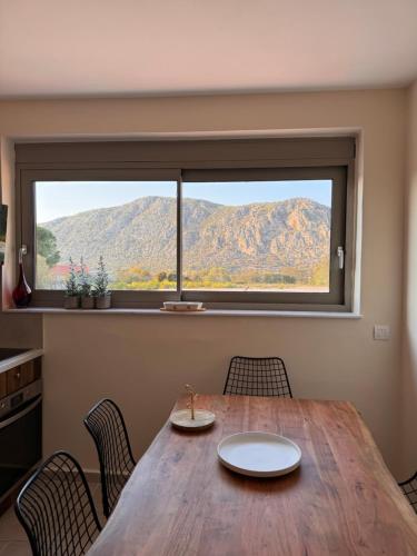 a dining room table with chairs and a large window at Topos luxury stay Heraion in Loutraki