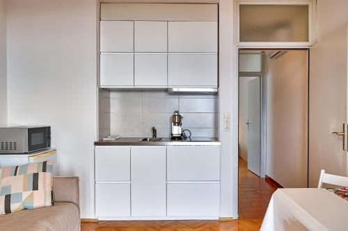 a white kitchen with a sink and a microwave at Apartments Frlan in Kastav