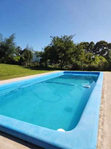 a large swimming pool with blue water at Cabañas La Retama in Tandil