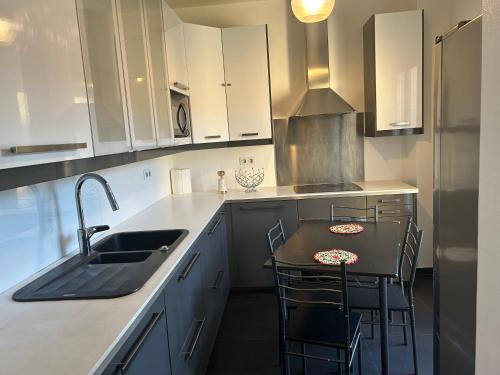 une cuisine avec un évier et une table avec des chaises dans l'établissement Chez Chantou à Pierrefitte sur Seine, à Pierrefitte-sur-Seine