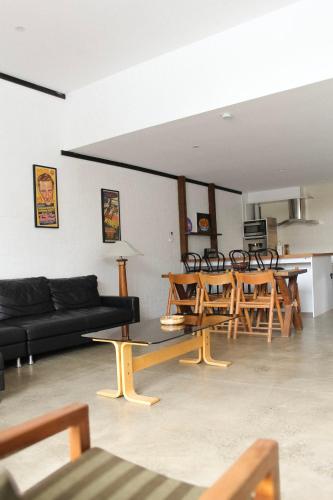 a living room with a black couch and wooden tables at Large Modern 3BR 2 BATH Apt in Central Location for Families, Workers, Groups in Fyshwick