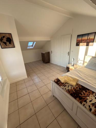 - une chambre avec un lit et du carrelage dans l'établissement Chez Chantou à Pierrefitte sur Seine, à Pierrefitte-sur-Seine