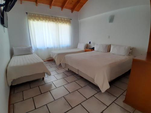 um quarto de hotel com duas camas e uma janela em Hotel Sur Sur Patagónico em Esquel