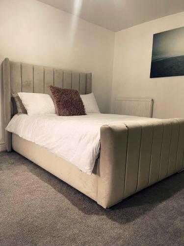 a large bed in a bedroom with a large headboard at Willow’s Abode: Luxury One Bed in Newton in Makerfield