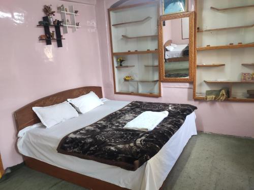sypialnia z dużym łóżkiem z lustrem w obiekcie Lake Boulevard Guest House w mieście Durgjan