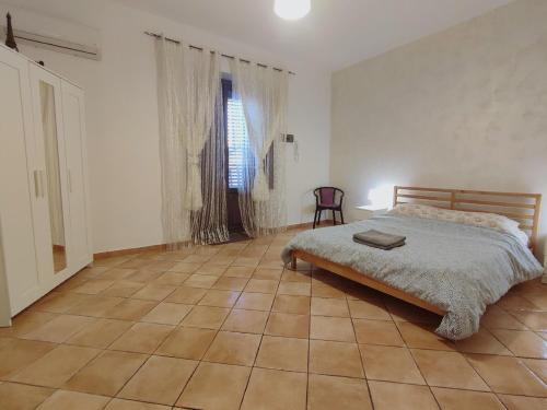 - une chambre avec un lit et du carrelage dans l'établissement Appartamento Aci Sant'Antonio, à Aci Catena