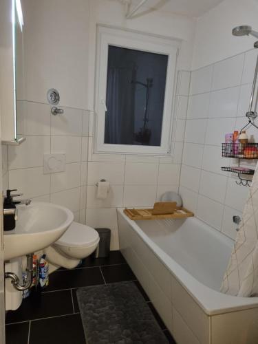 a bathroom with a tub and a toilet and a sink at Weserbergland Apartment in Bodenwerder
