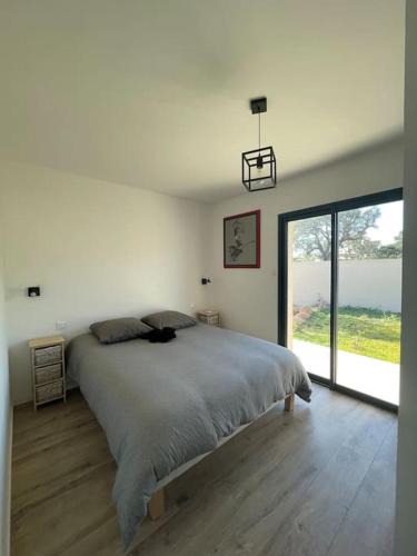 une chambre avec un grand lit et une grande fenêtre dans l'établissement Villa Imagine, à Lecci