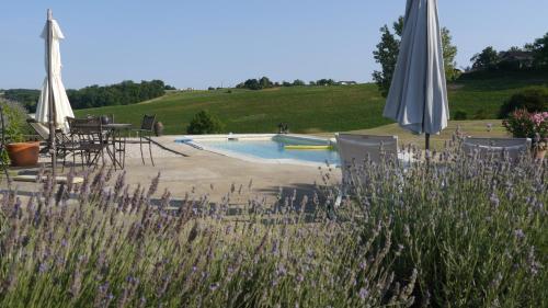 - un billard avec des tables, des chaises et un parasol dans l'établissement Bel-Endroit, à Marciac