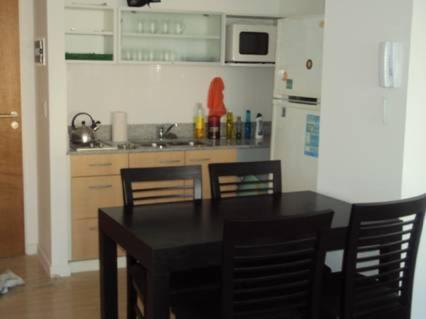 una cocina con mesa negra y sillas. en Palermo Soho Apartamento en Buenos Aires