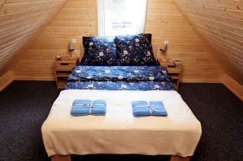 a bedroom with two beds with blue towels on it at Domek letniskowy Letniczówka in Warchały