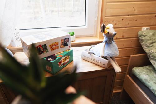 a table with books and a stuffed animal on top of it at Domek letniskowy Letniczówka in Warchały
