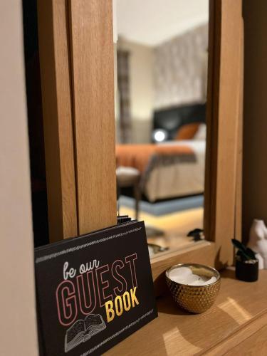 a sign for a guest book sitting on a table in front of a mirror at The Starlings Country House in Wexford