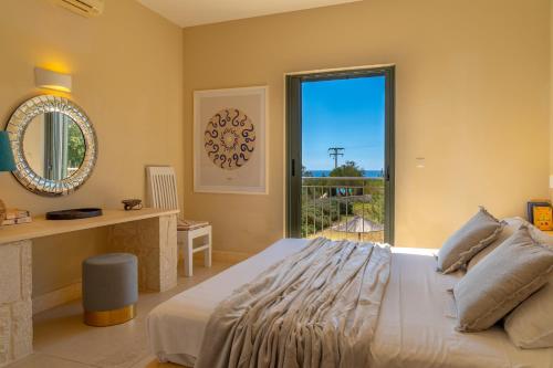 a bedroom with a large bed and a large window at Sunny Villas in Klísmata