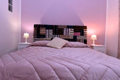a purple bedroom with a large bed with two lamps at In Terrazza Da Giusy in Rome