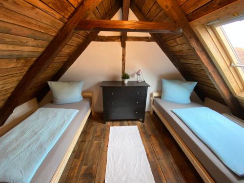 2 camas num quarto no sótão com tectos em madeira em Urlaubshof Altkö em Radebeul