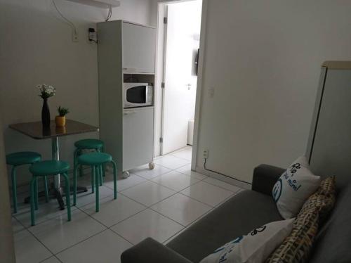ein Wohnzimmer mit einem Sofa und einem Tisch sowie eine Küche in der Unterkunft Vista Mar - Studio em Copacabana a 1 min da praia e próximo ao metrô in Rio de Janeiro
