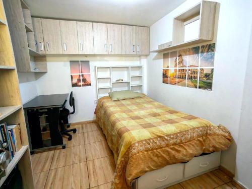 1 dormitorio pequeño con 1 cama y chimenea en Apartamento en El Tambo - Huancayo, en Huancayo