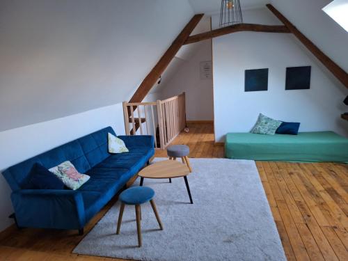- un salon avec un canapé bleu et un lit dans l'établissement Cottage Romy Siouville Hague, à Siouville
