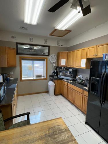 a kitchen with wooden cabinets and a black refrigerator at Sportsman Motel in Malta