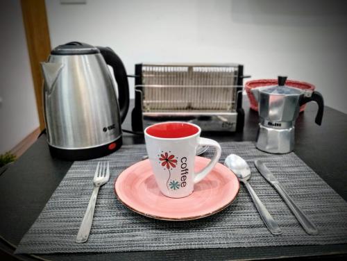 a table with a cup and a plate with a coffee mug at ALOJAMIENTO LANZA en el CORAZÓN DE SEVILLA in Seville