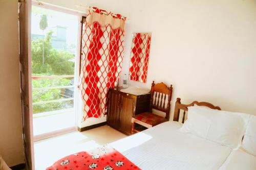 a bedroom with a bed and a large window at Eden Homestay Alleppey in Alleppey