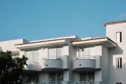 - un bâtiment avec balcon et ciel bleu dans l'établissement Prinsotel La Pineda, à Cala Ratjada