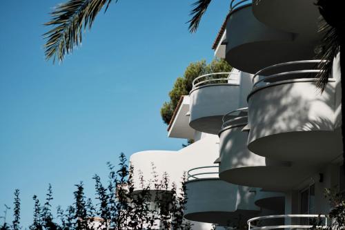 a close up of a building with trees in the background at Prinsotel La Pineda in Cala Ratjada