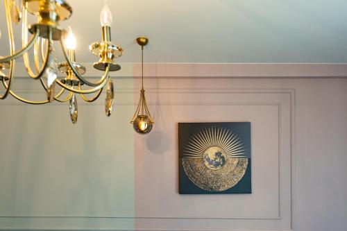 a chandelier and a picture on a wall at Trinity Hotel in Tbilisi City