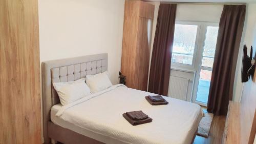 een slaapkamer met een bed met twee handdoeken erop bij Apartament Comfortable Fortuna in Sfântu-Gheorghe